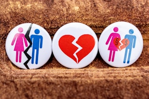 three buttons depicting a broken heart, a man and a woman