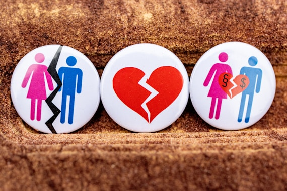 three buttons depicting a broken heart, a man and a woman