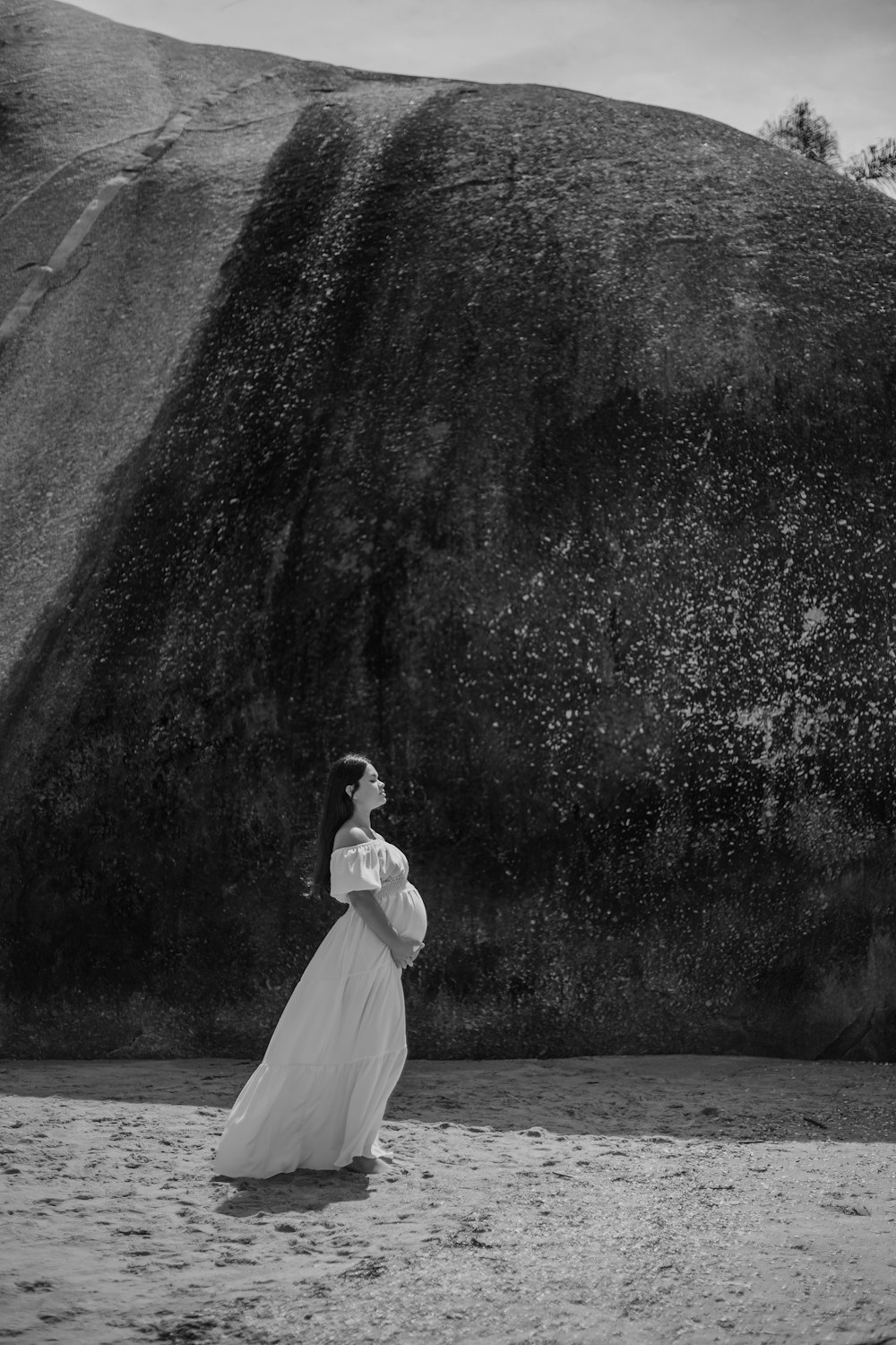 a black and white photo of a woman in a dress