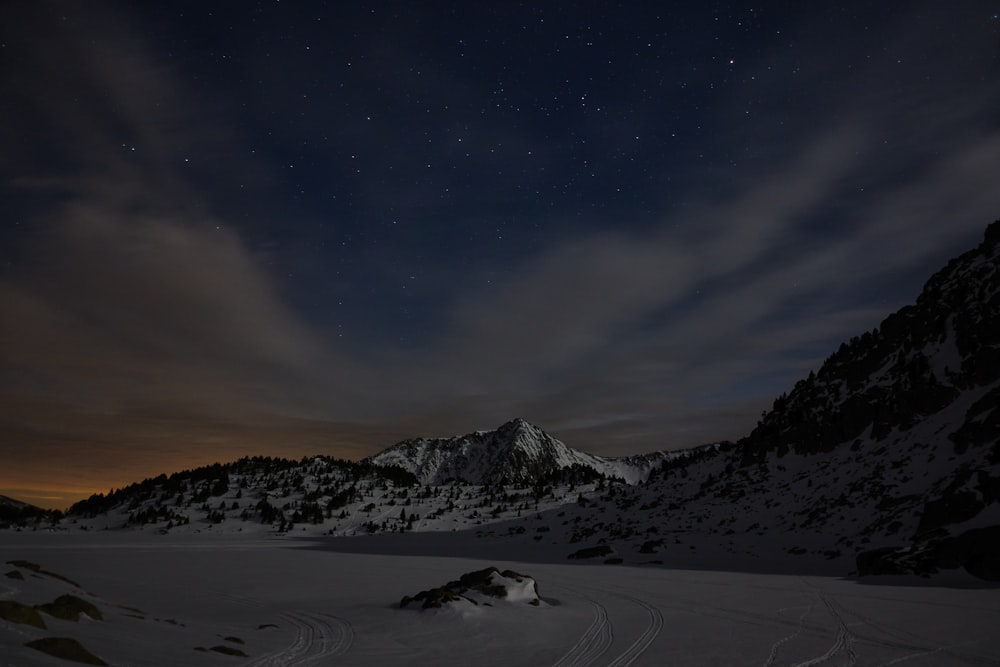 a snow covered mountain under a night sky