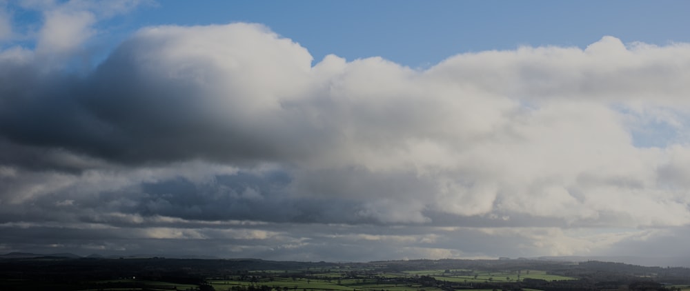 Blick auf ein Feld mit vielen Wolken am Himmel