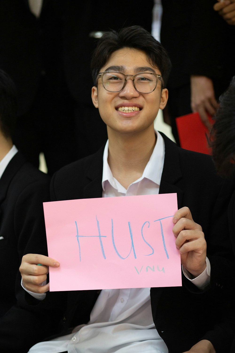 a young man holding a sign that says hush