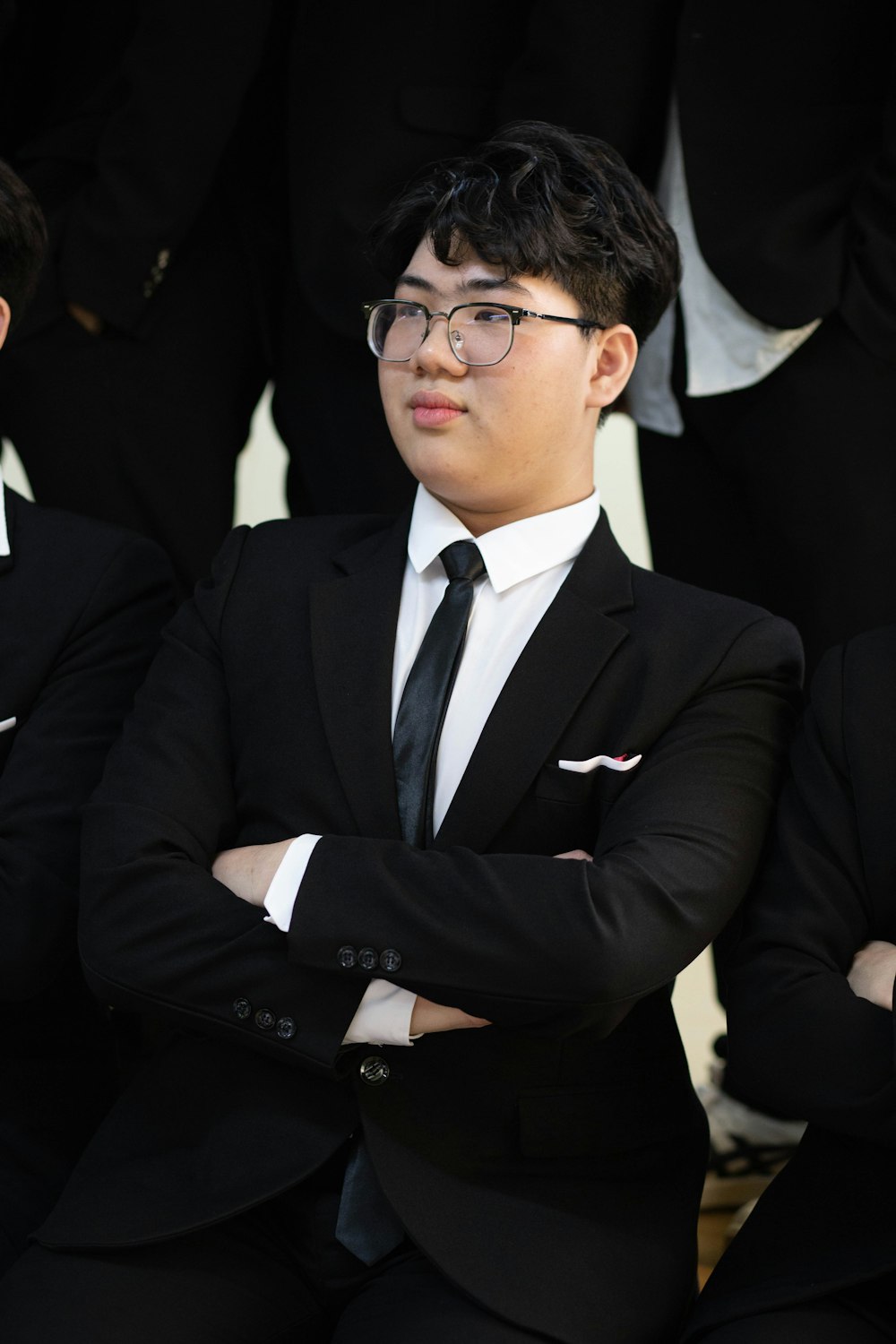 a man in a suit and tie standing with his arms crossed