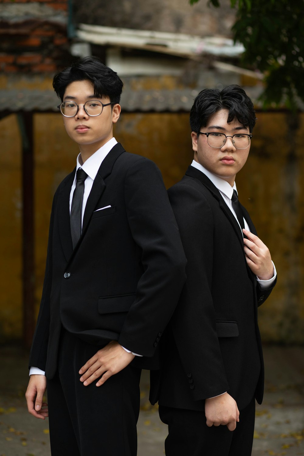 two young men in suits standing next to each other