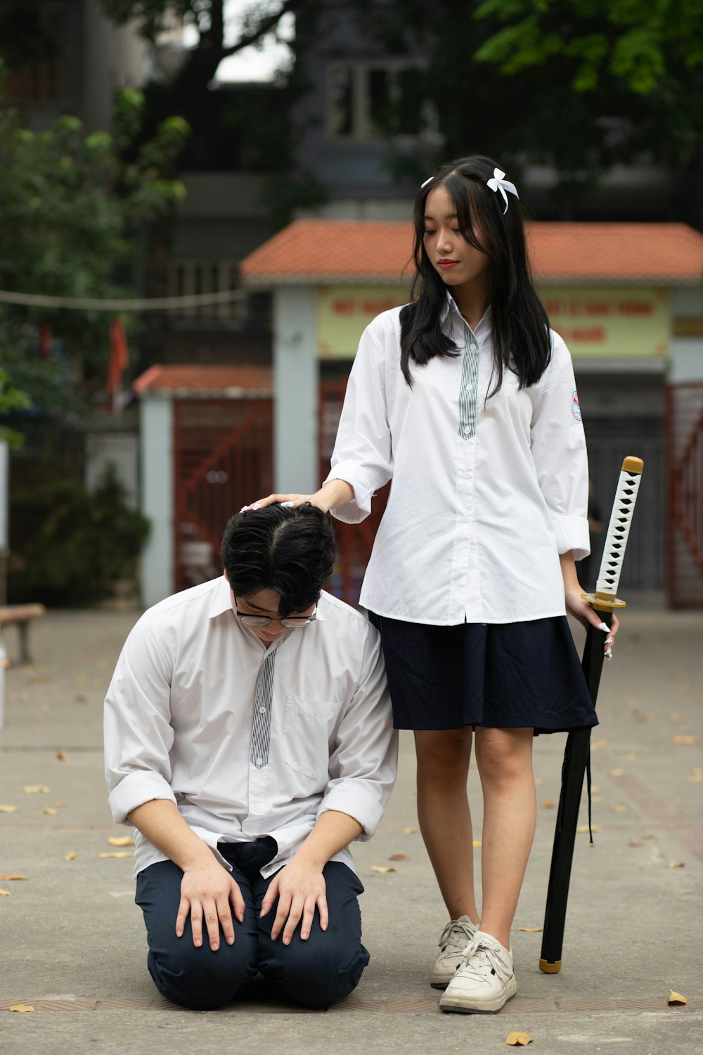 a man kneeling down next to a woman holding a bat