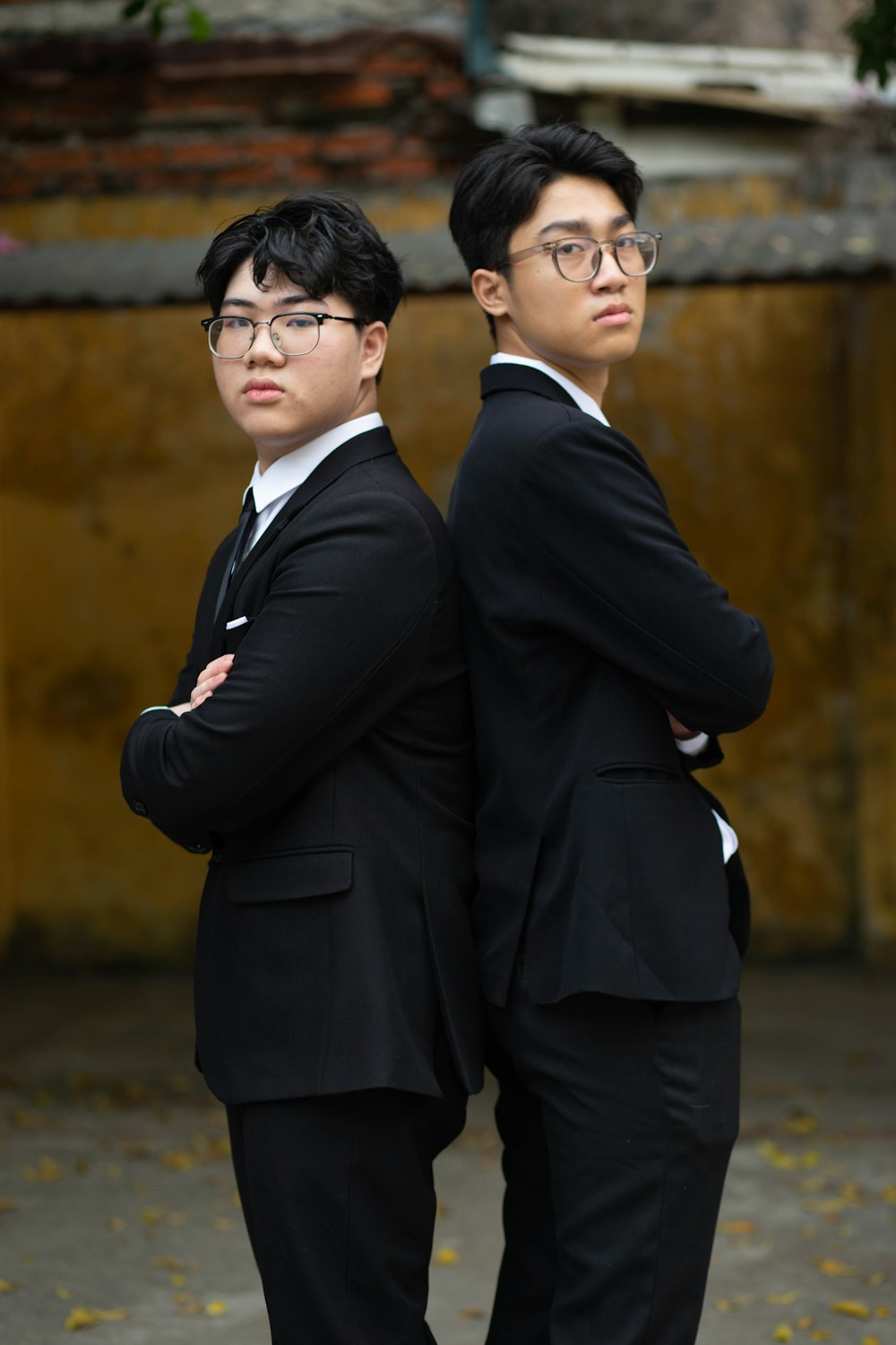 two asian men in suits standing next to each other