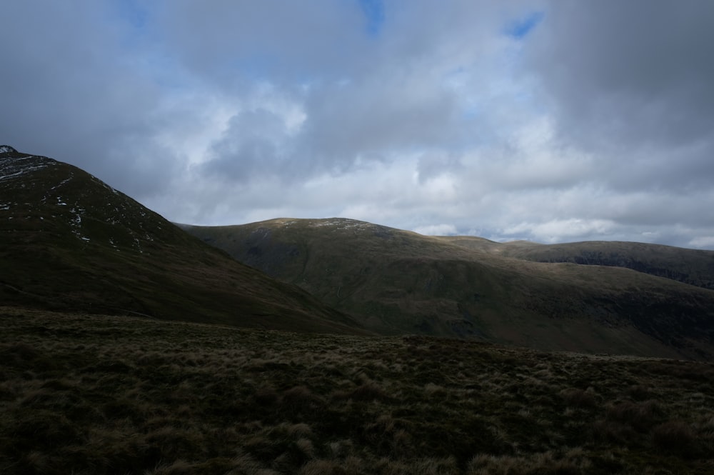 a mountain range with a cloudy sky in the background