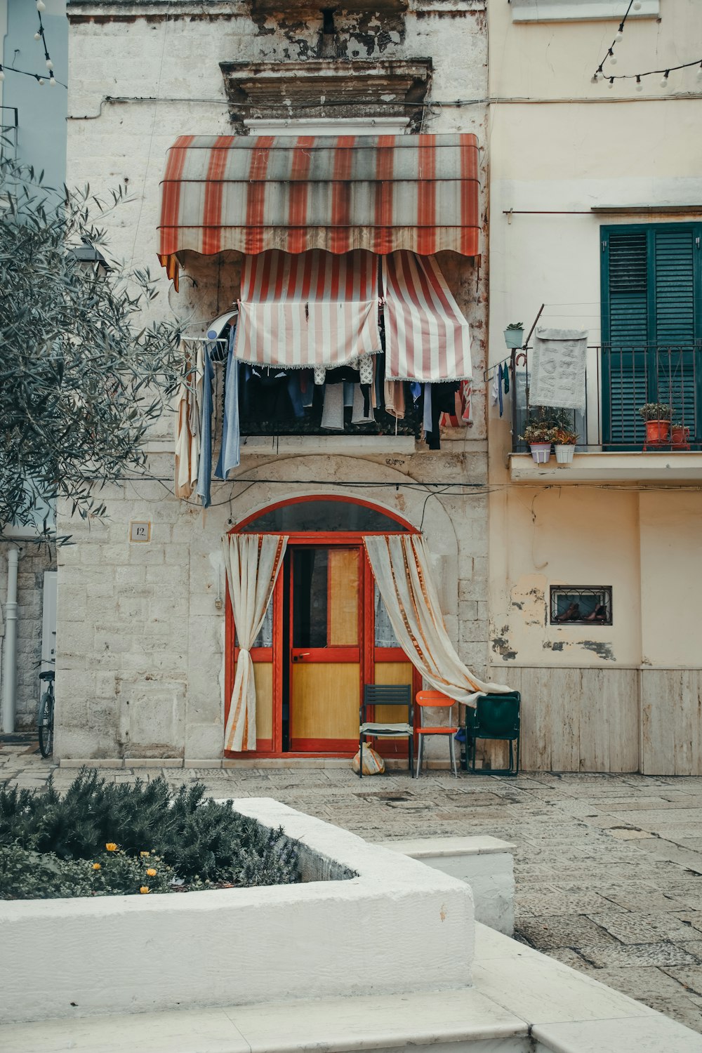 a building with a striped awning next to a tree