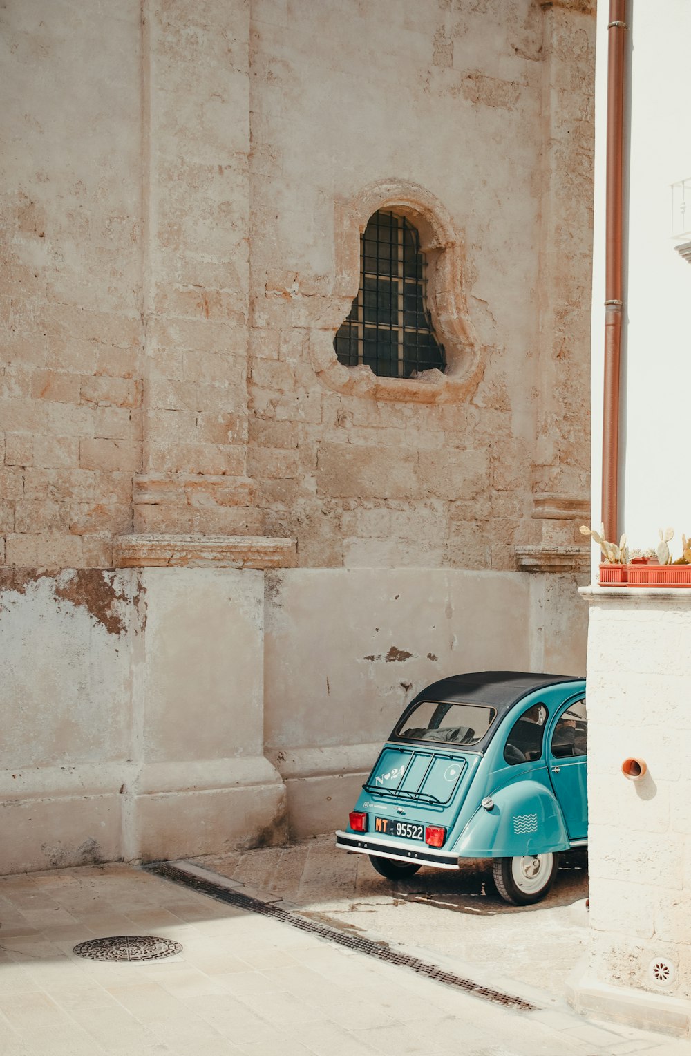 a small blue car parked in front of a building