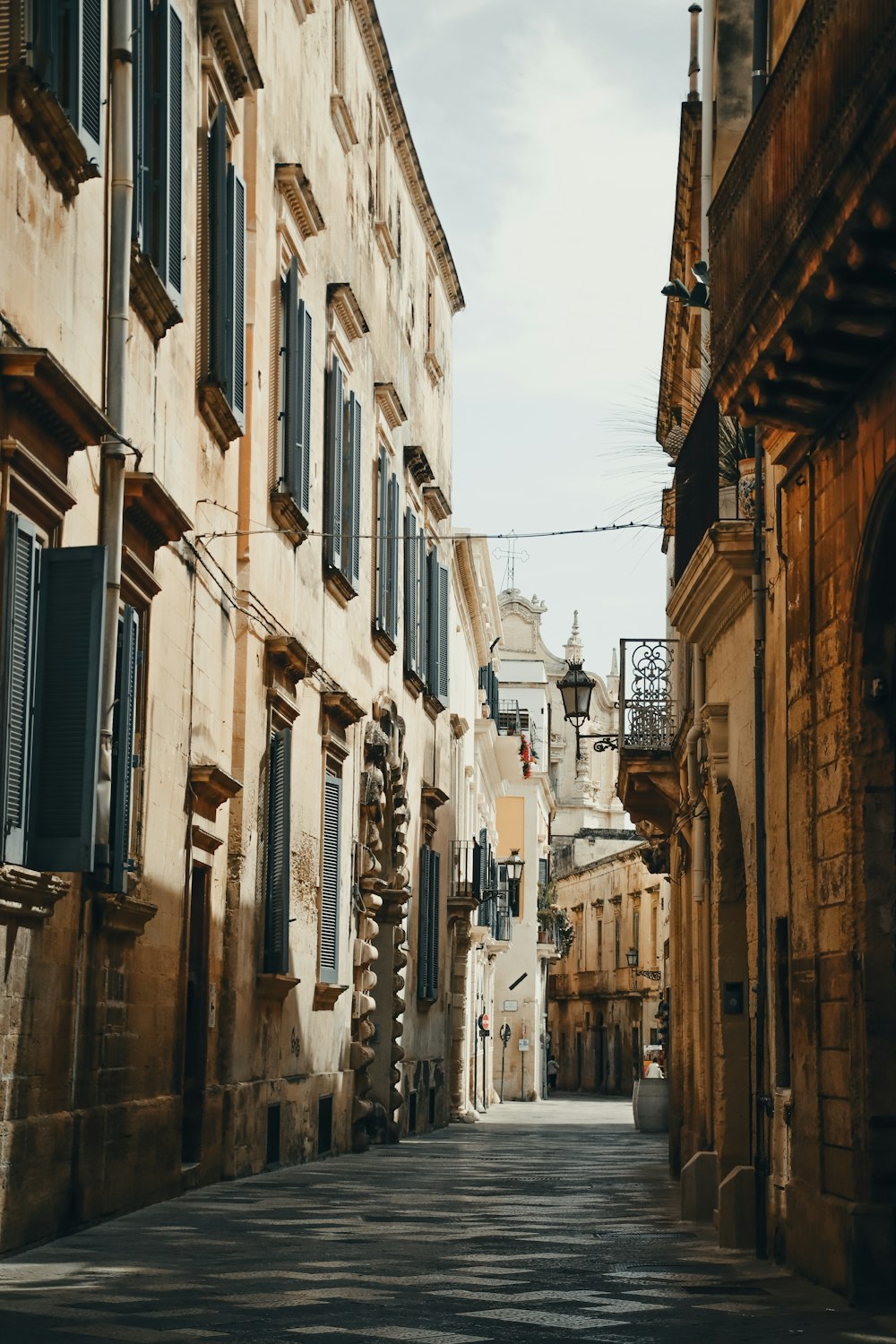 a narrow street lined with stone buildings and shutters