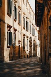 a narrow street lined with stone buildings and shutters