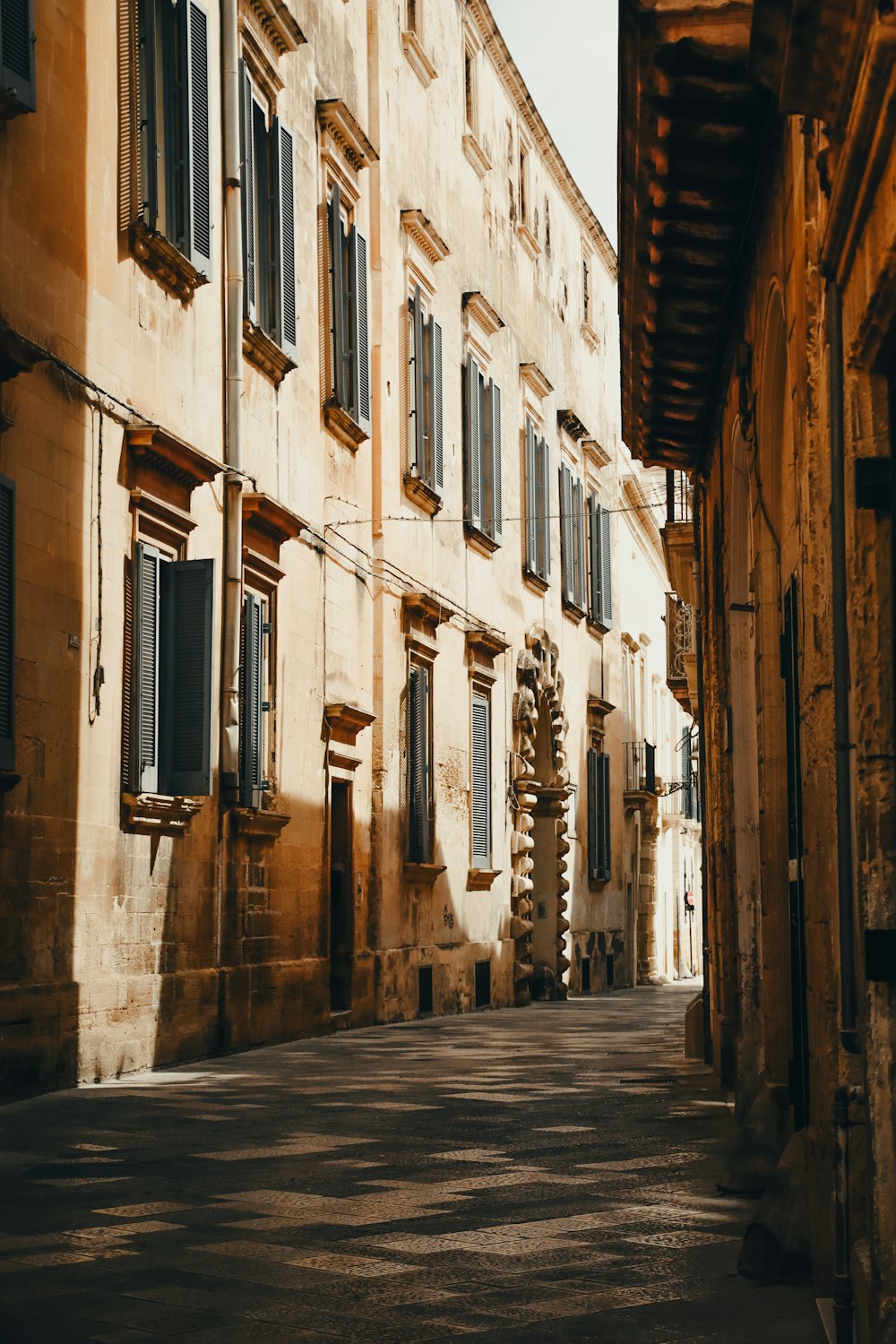 a narrow street lined with stone buildings and shutters