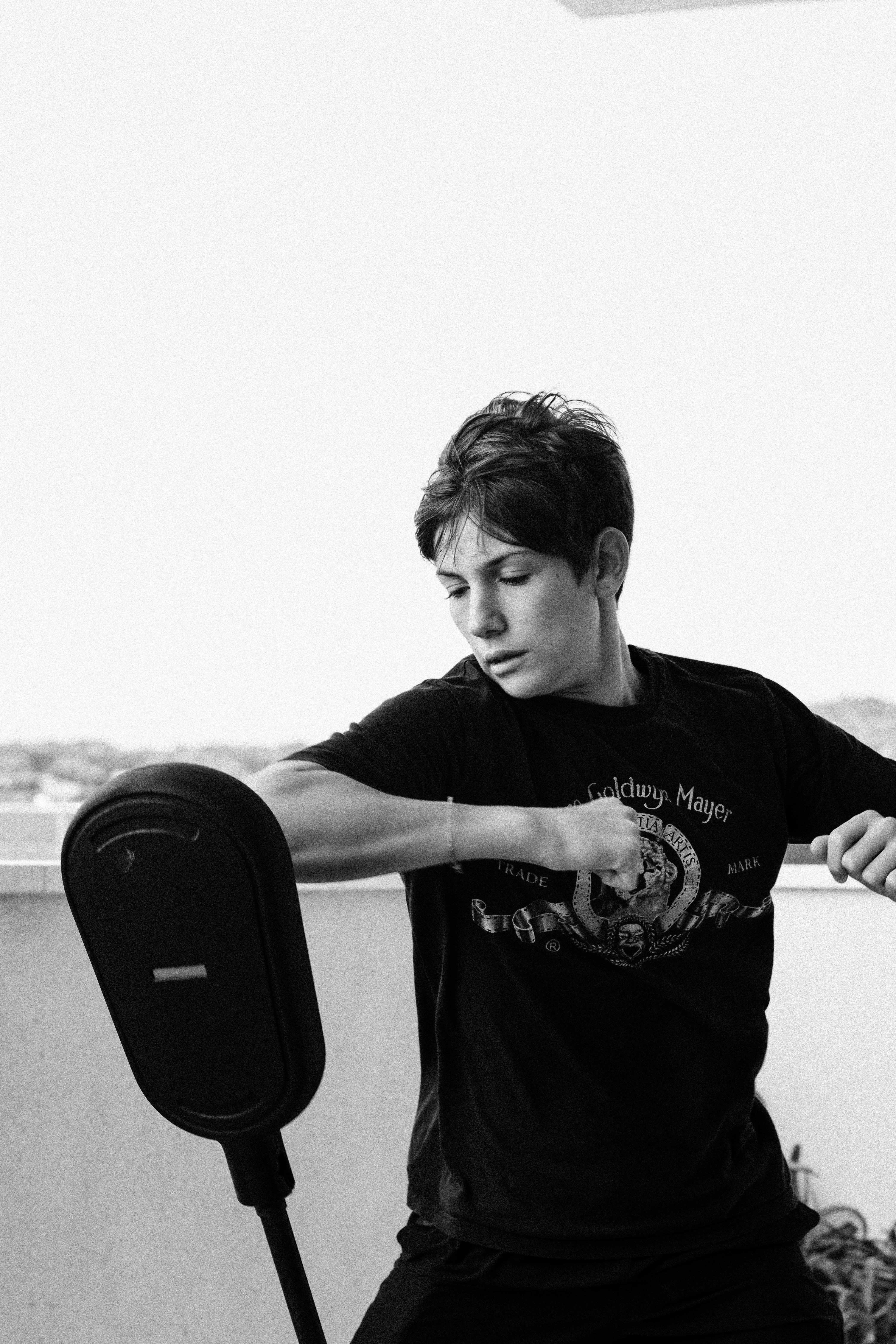 a man sitting on a bench with his hand on the back of a chair