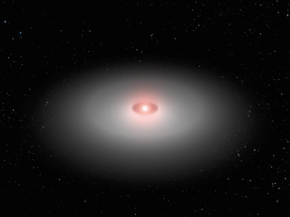 a black hole with a red disk in the middle of it