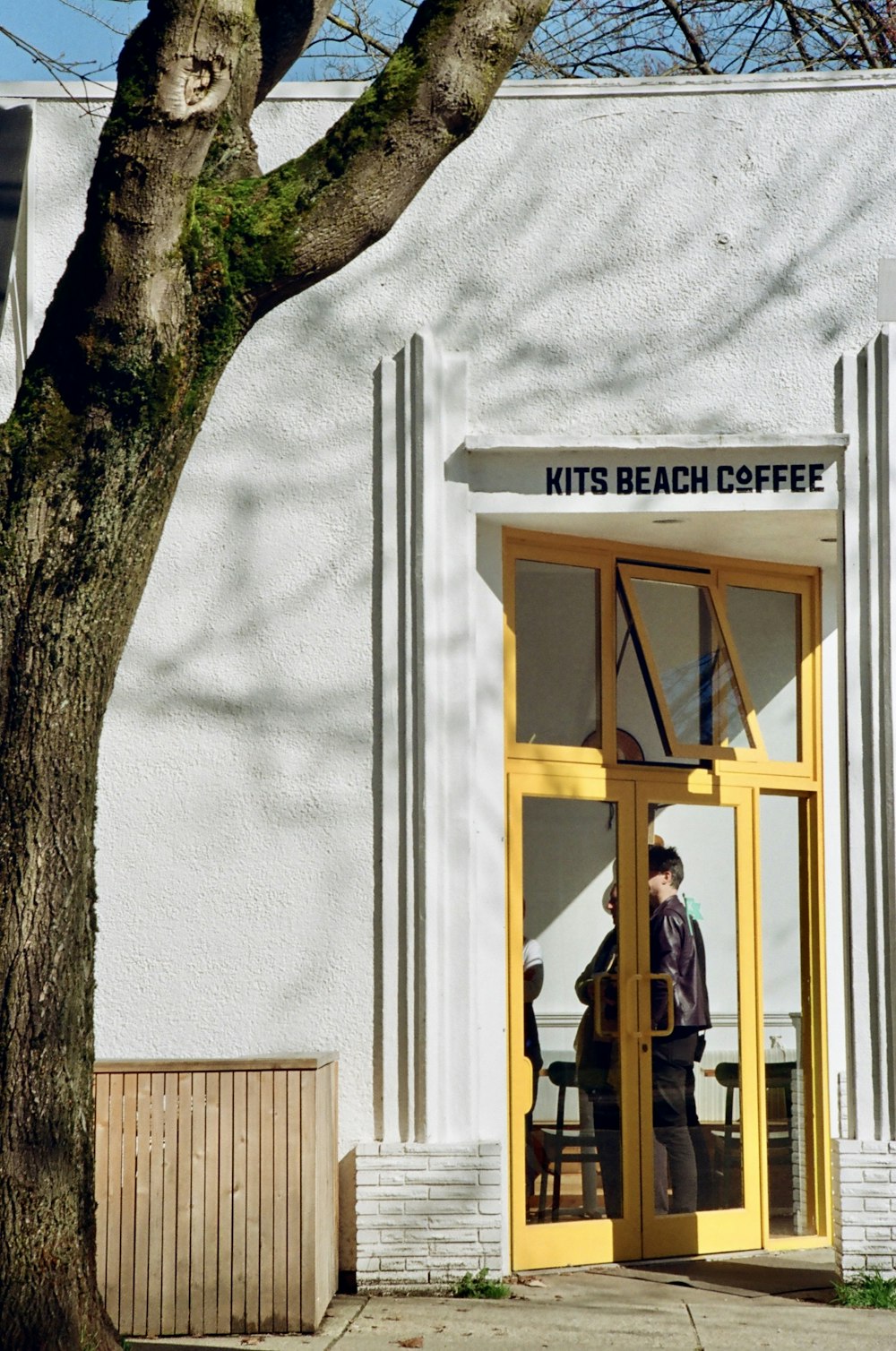 a man standing in a doorway of a white building