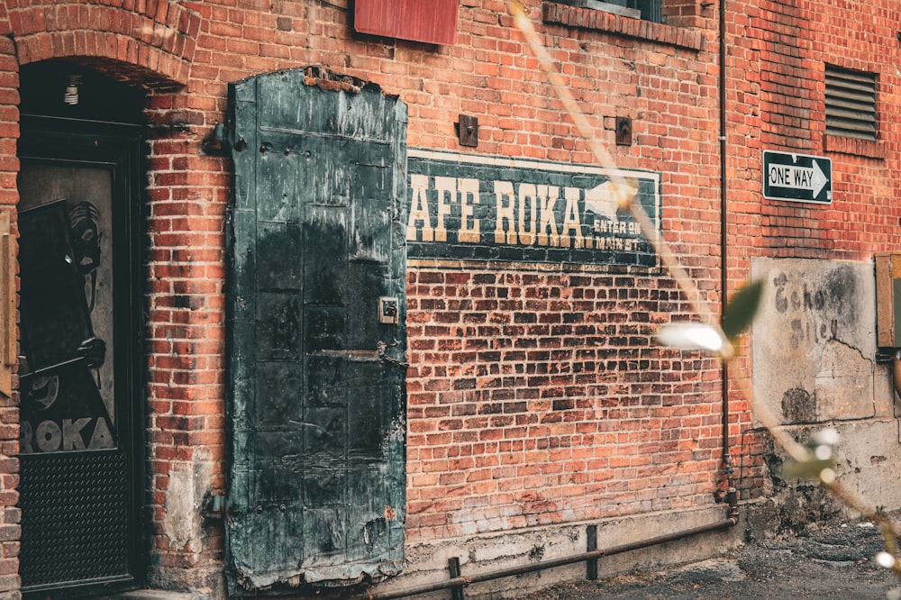 a brick building with a door and a sign on it