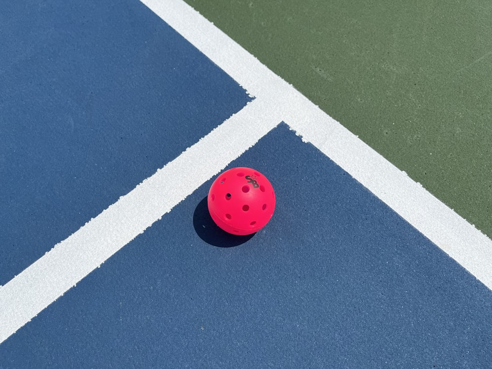 a red ball on a blue tennis court