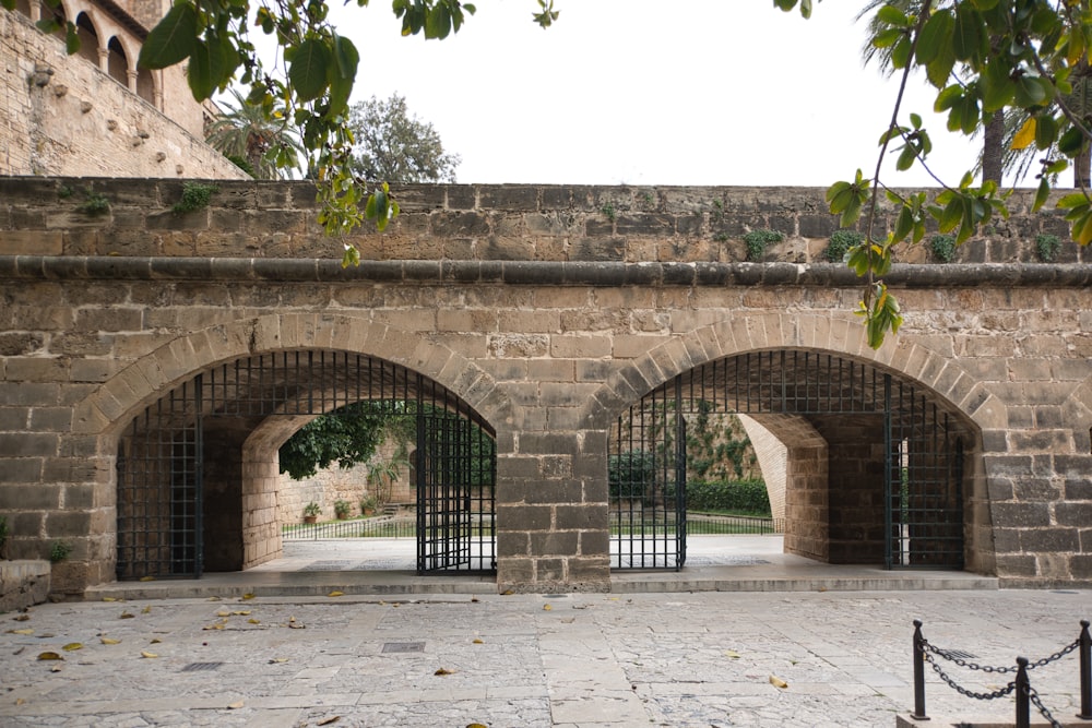 a stone wall with four arched doorways in it