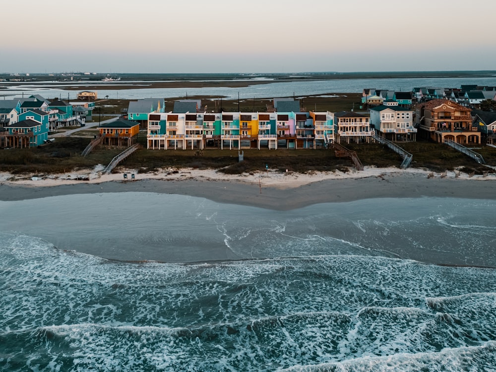 an aerial view of a beach with houses in the background