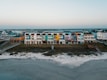 a row of multi - colored houses on a beach