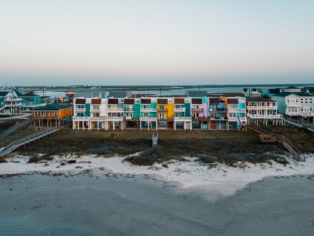 a row of multi - colored houses on a beach