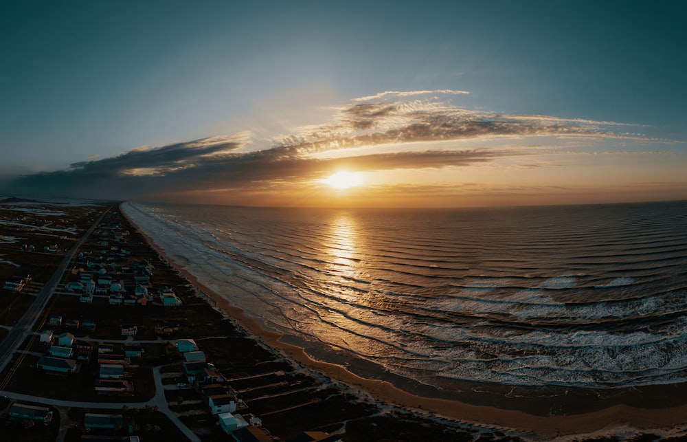 the sun is setting over the ocean and the beach