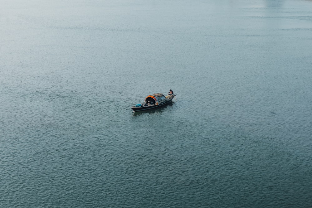 two people in a small boat on a large body of water