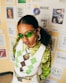 a woman wearing green sunglasses and a sweater