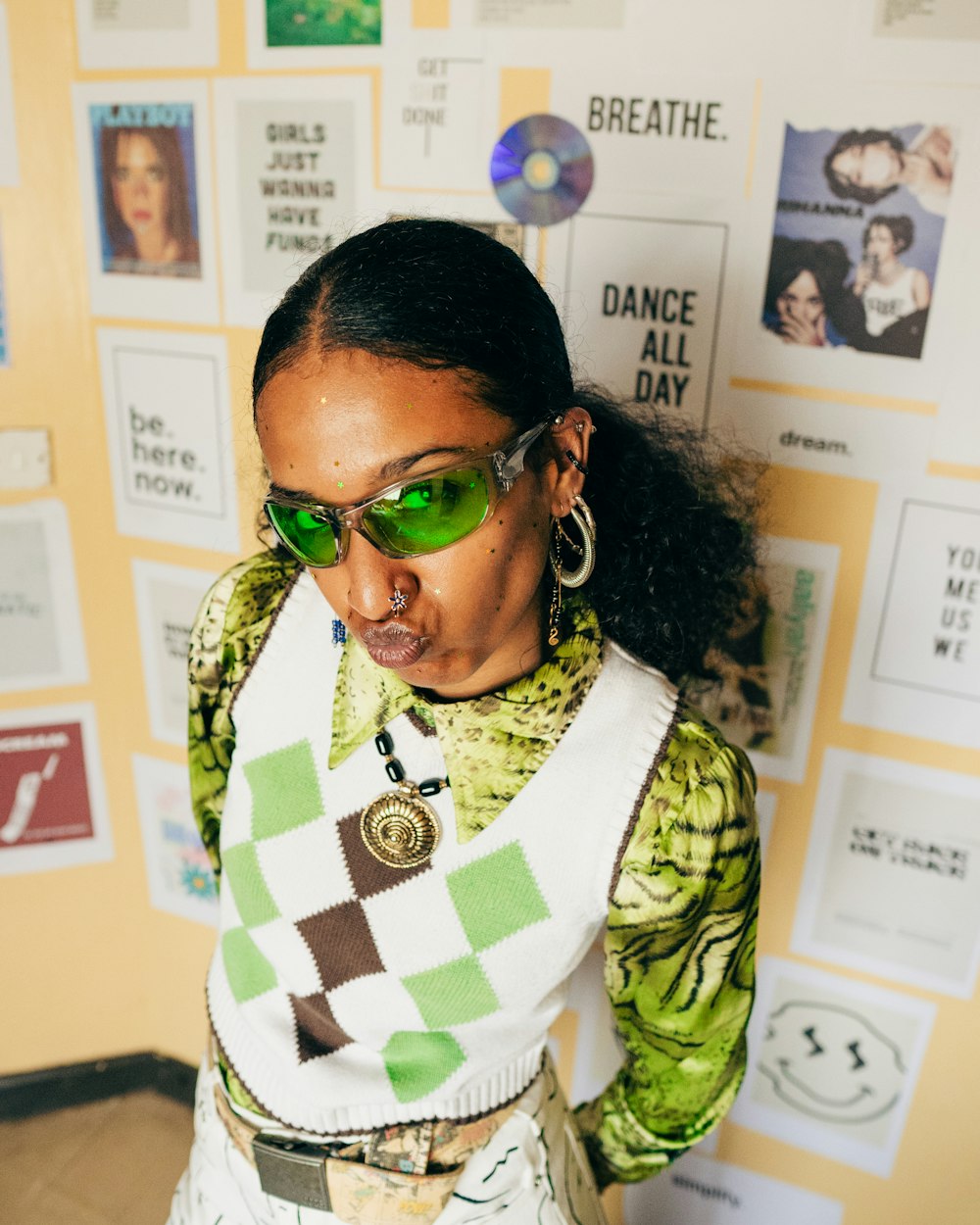 une femme portant des lunettes de soleil vertes et un pull