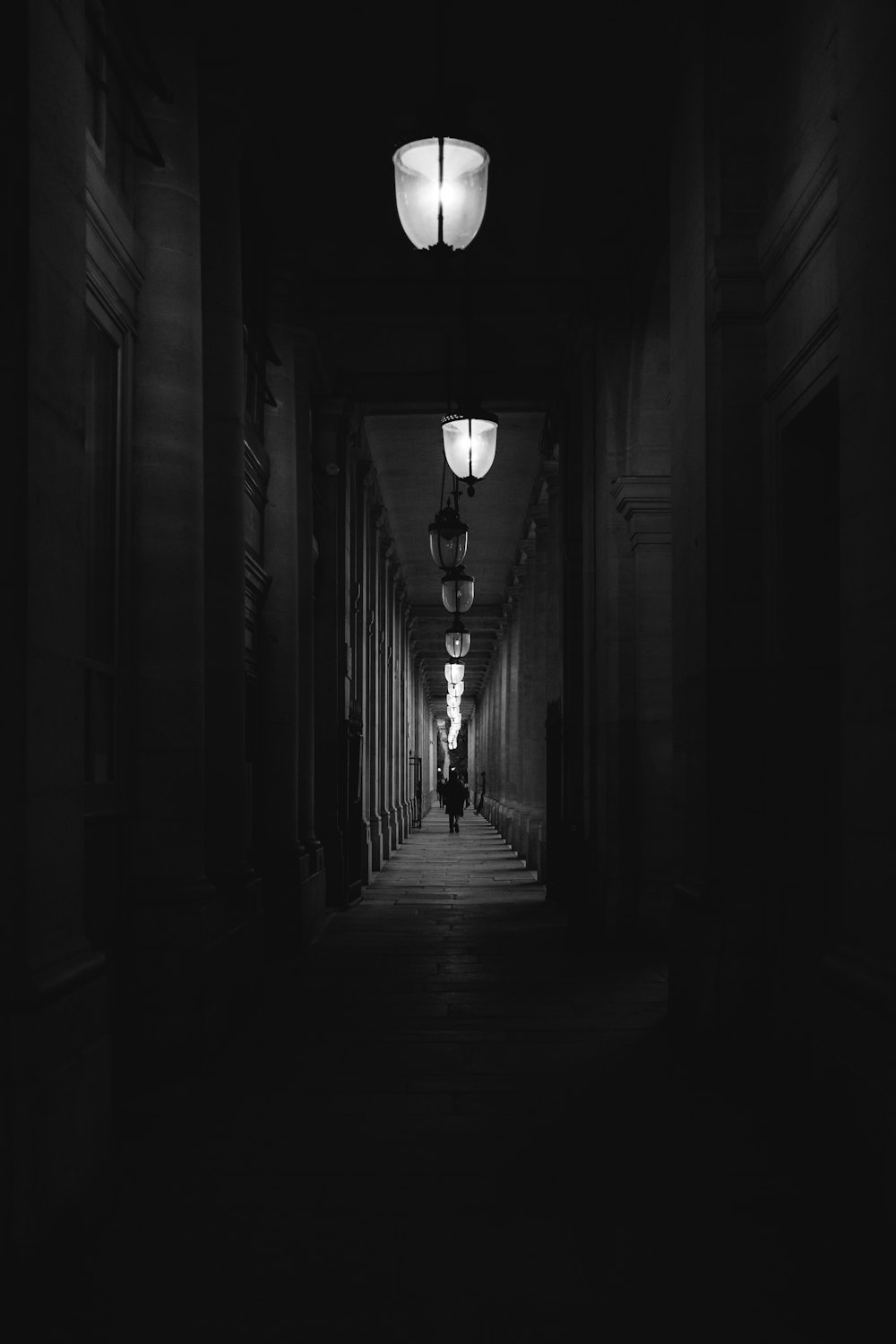 a person walking down a dark hallway at night