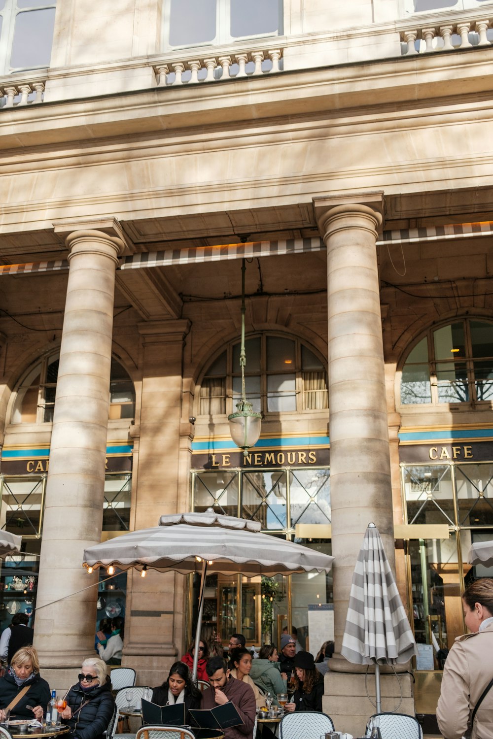 a group of people sitting at tables in front of a building