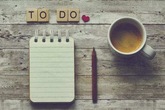 a cup of coffee next to a notepad with the words to do on it