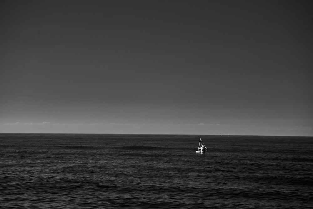a sailboat floating in the middle of the ocean