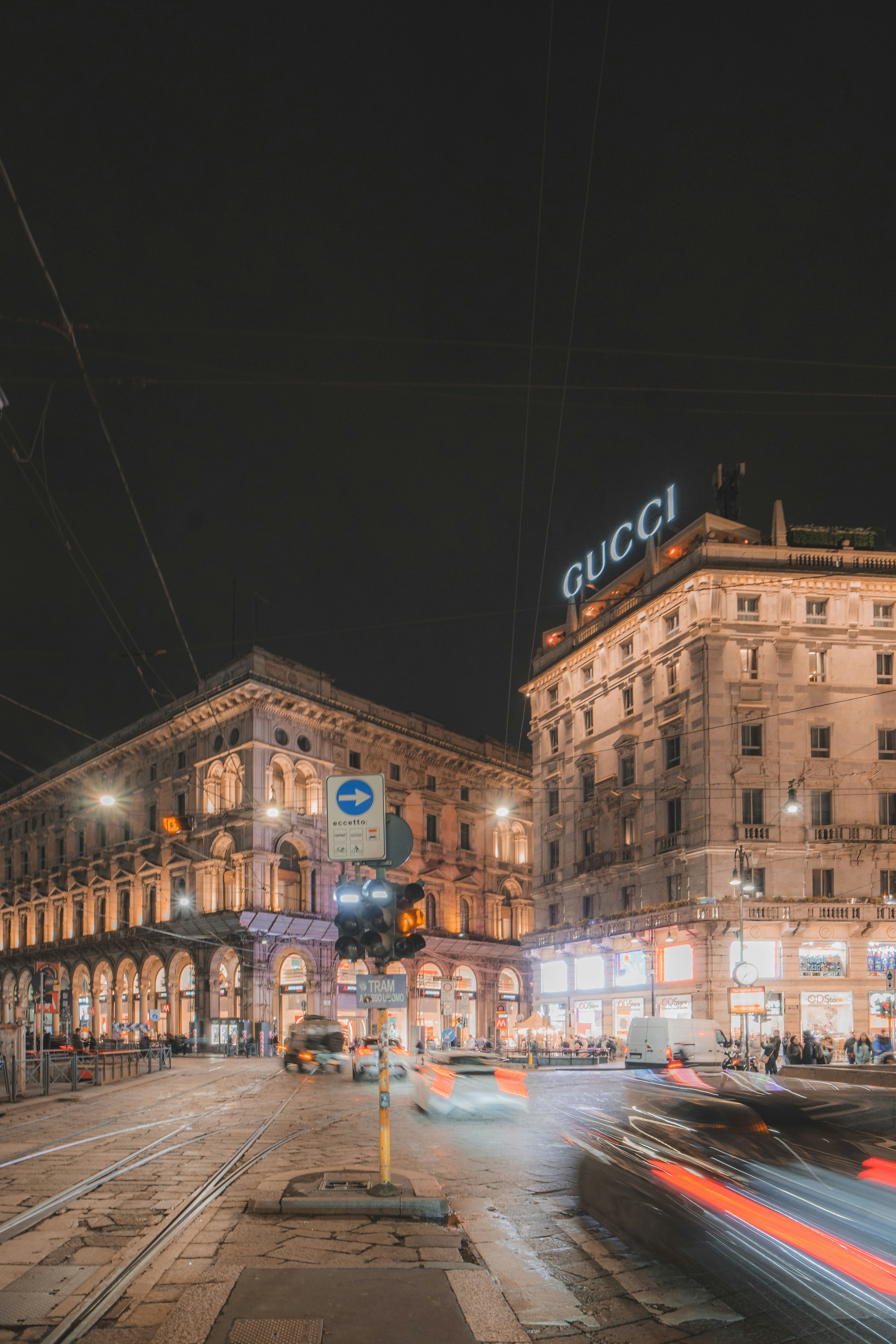una strada trafficata della città di notte con un edificio sullo sfondo