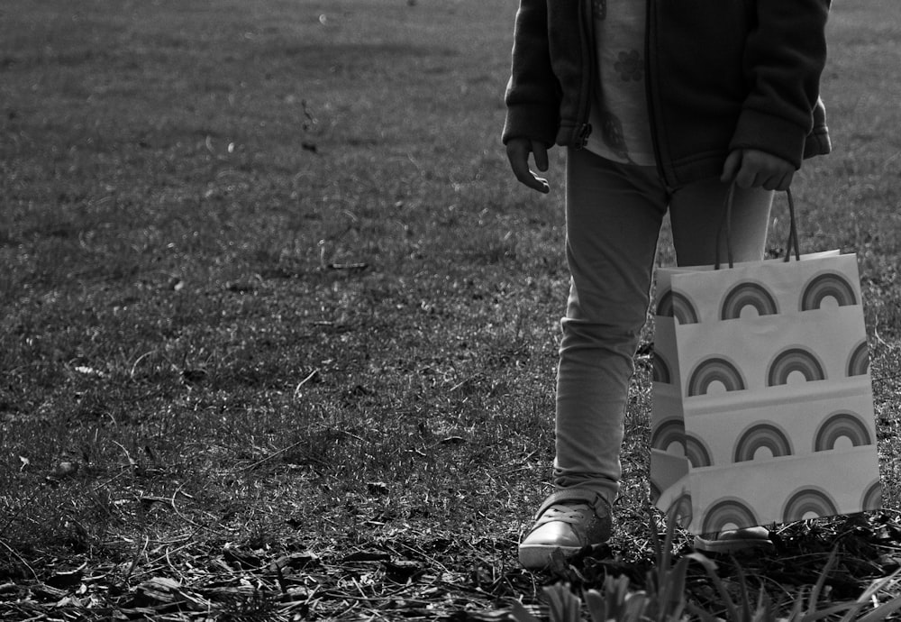 uma criança carregando uma bolsa com um desenho de arco-íris sobre ela