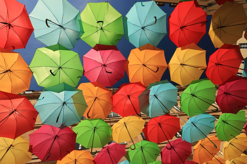 a bunch of colorful umbrellas are hanging up