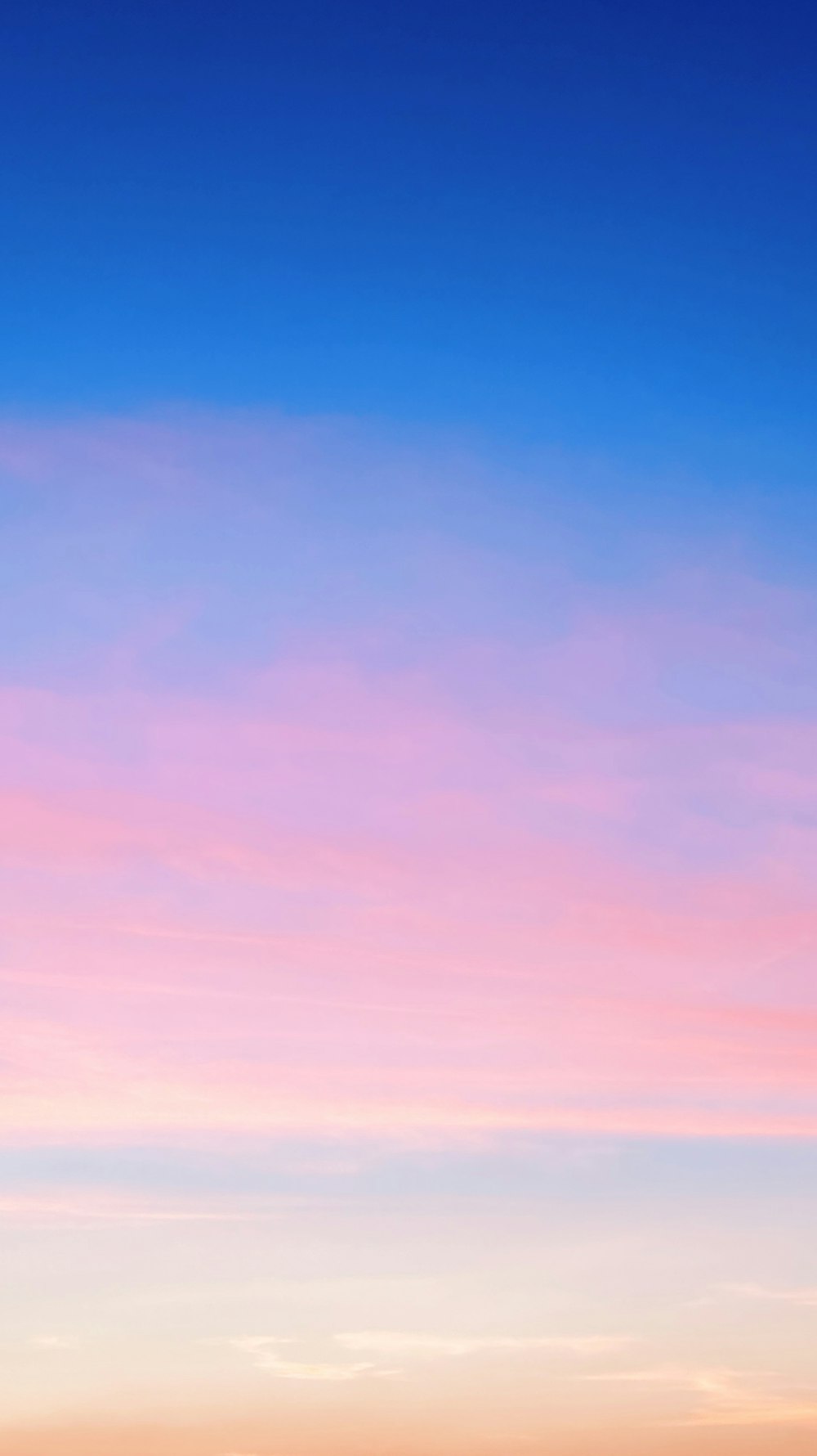 a plane flying in the sky at sunset