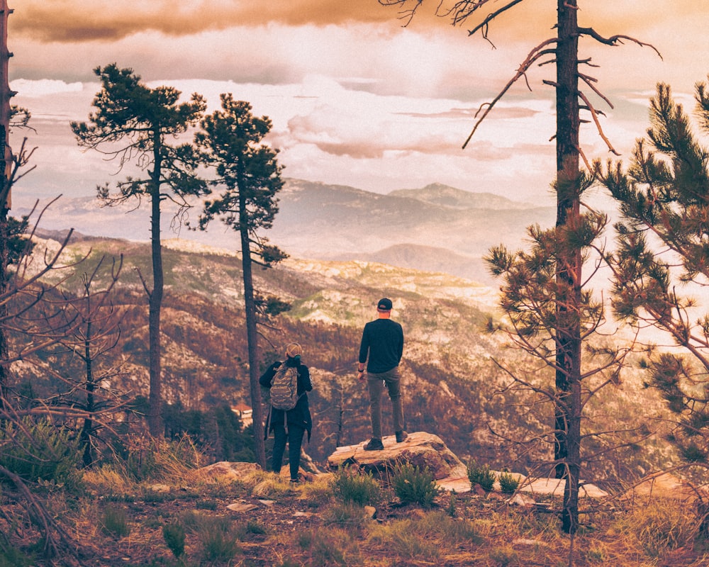 a couple of people standing on top of a mountain