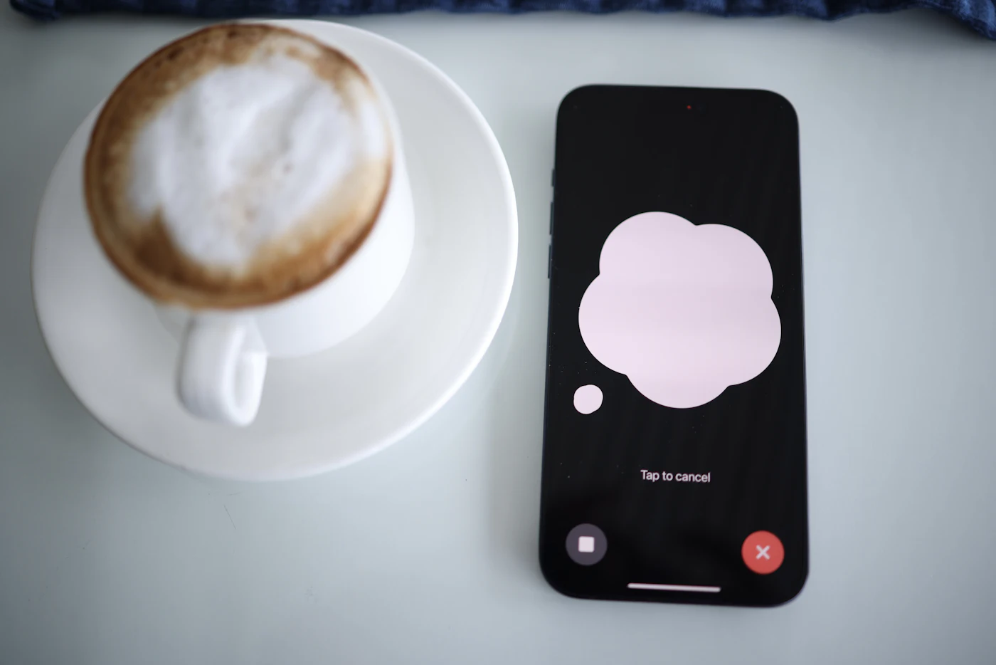 Taza de café junto a un móvil con ChatGPT en modo voz