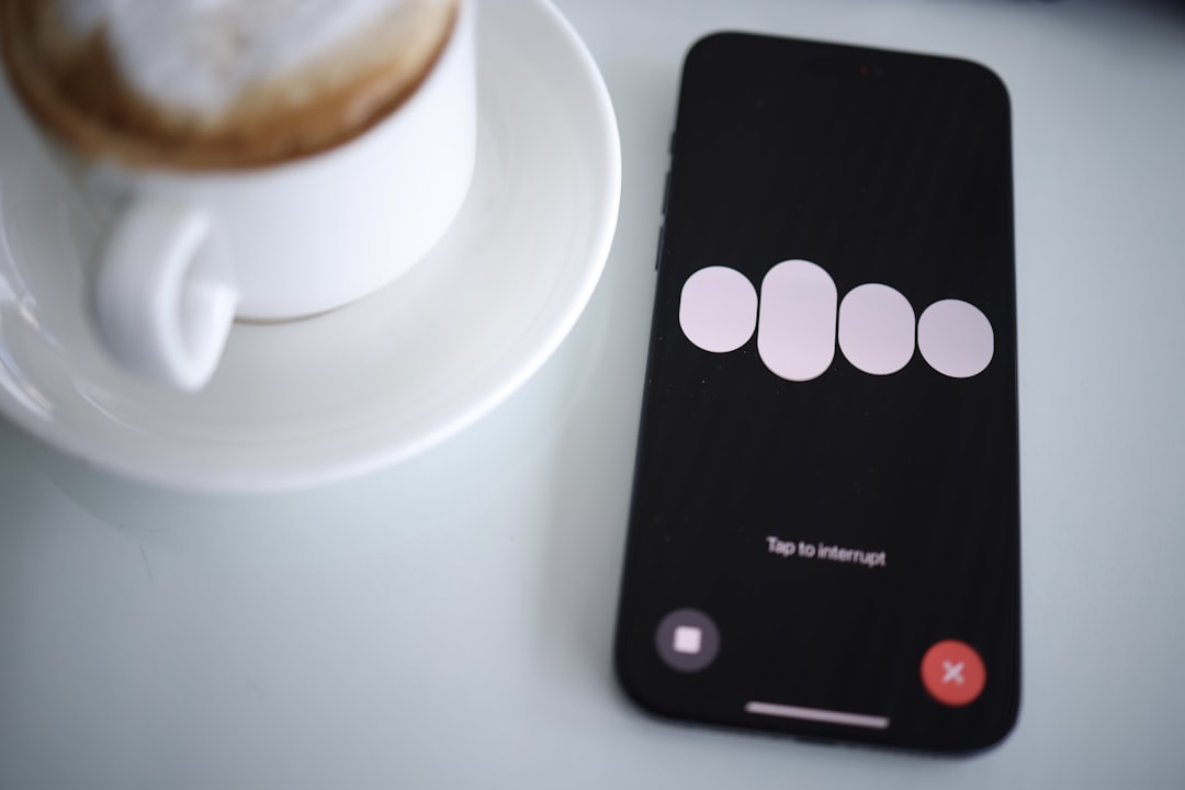 a cell phone sitting next to a cup of coffee,