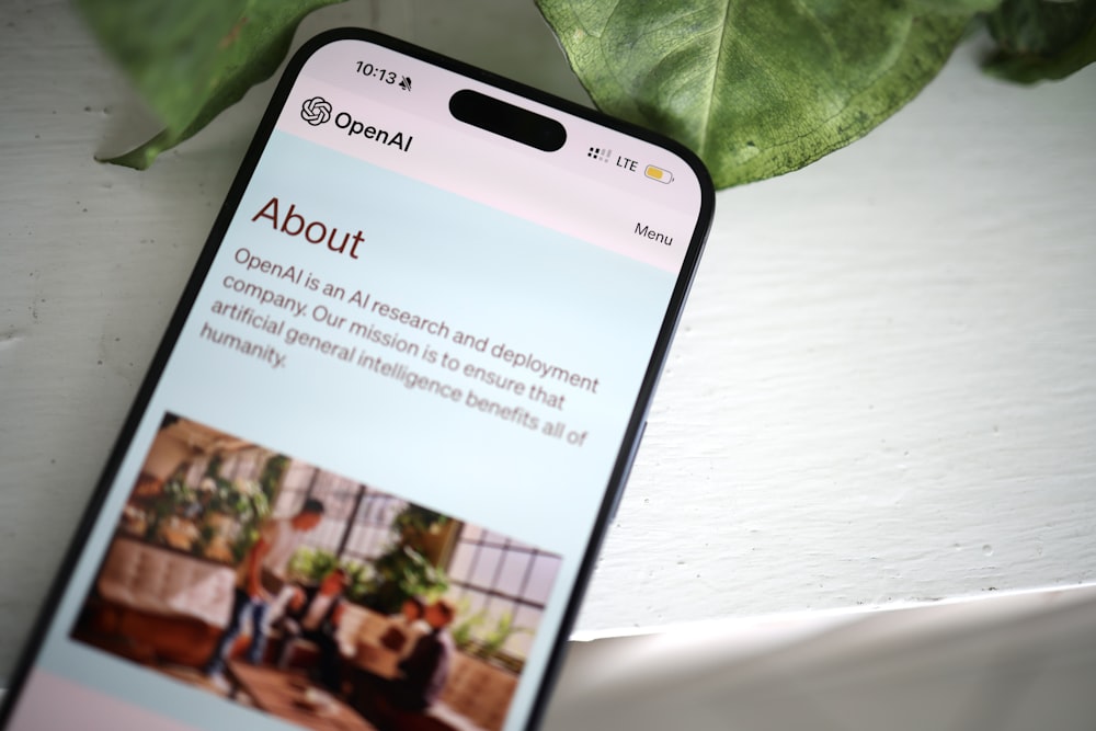 a cell phone sitting on top of a table next to a plant