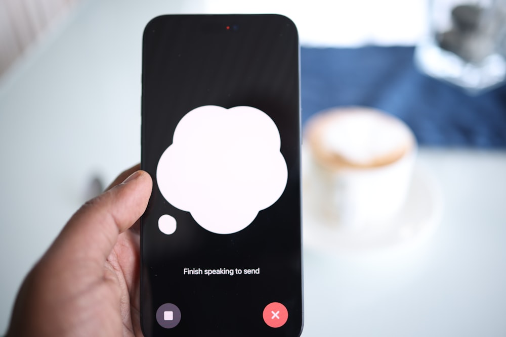 une personne tenant un téléphone cellulaire avec une bulle de dialogue à l’écran