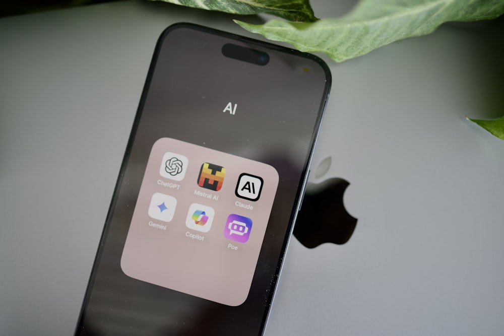 an iphone sitting on top of a table next to a leaf