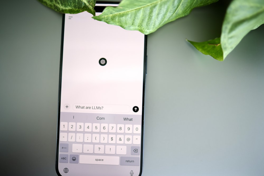 a cell phone with a keyboard and a plant