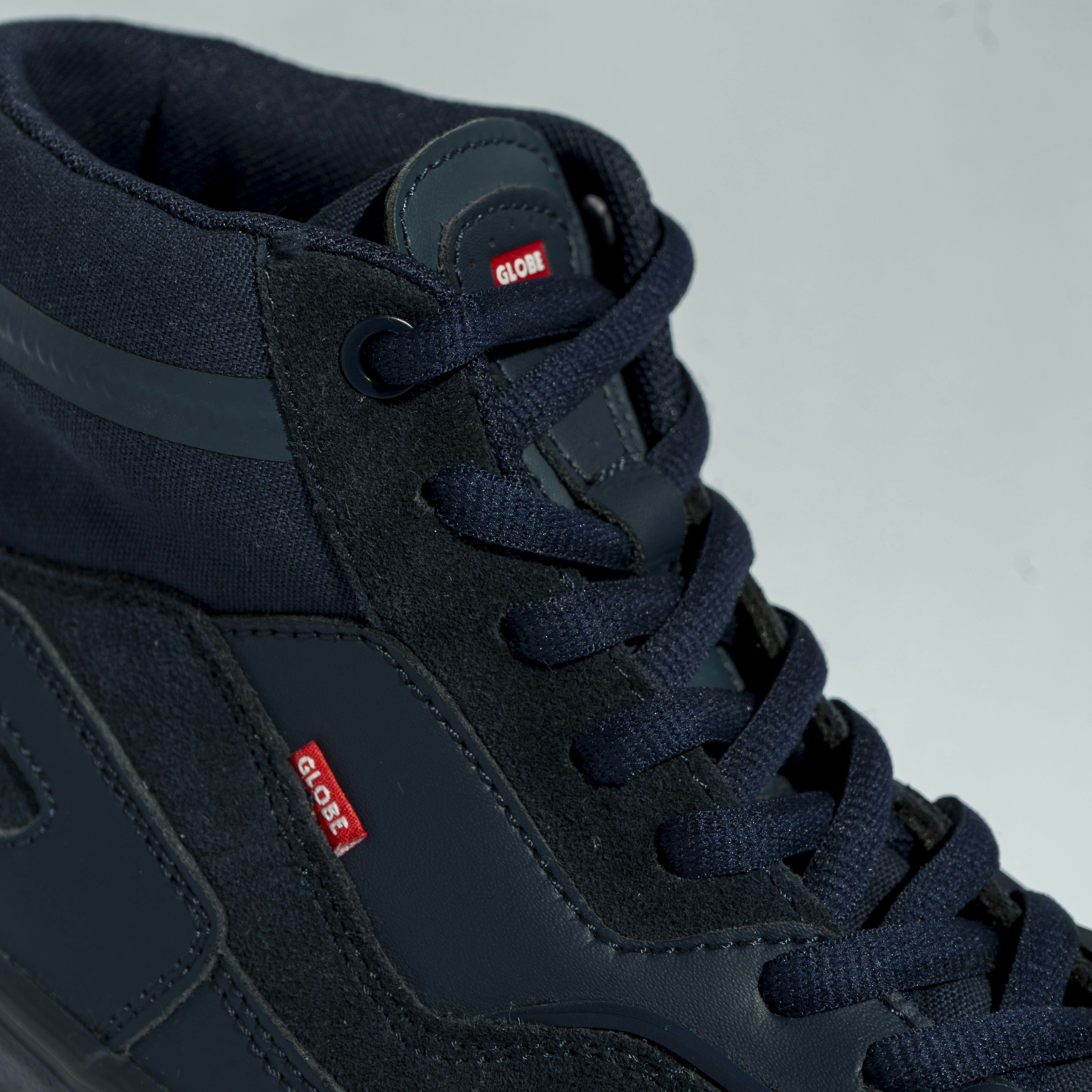 a pair of black sneakers with red and blue laces