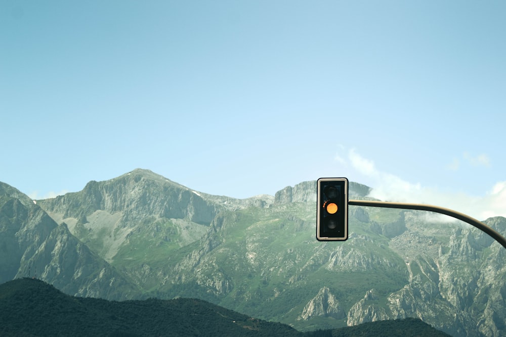 a traffic light with mountains in the background