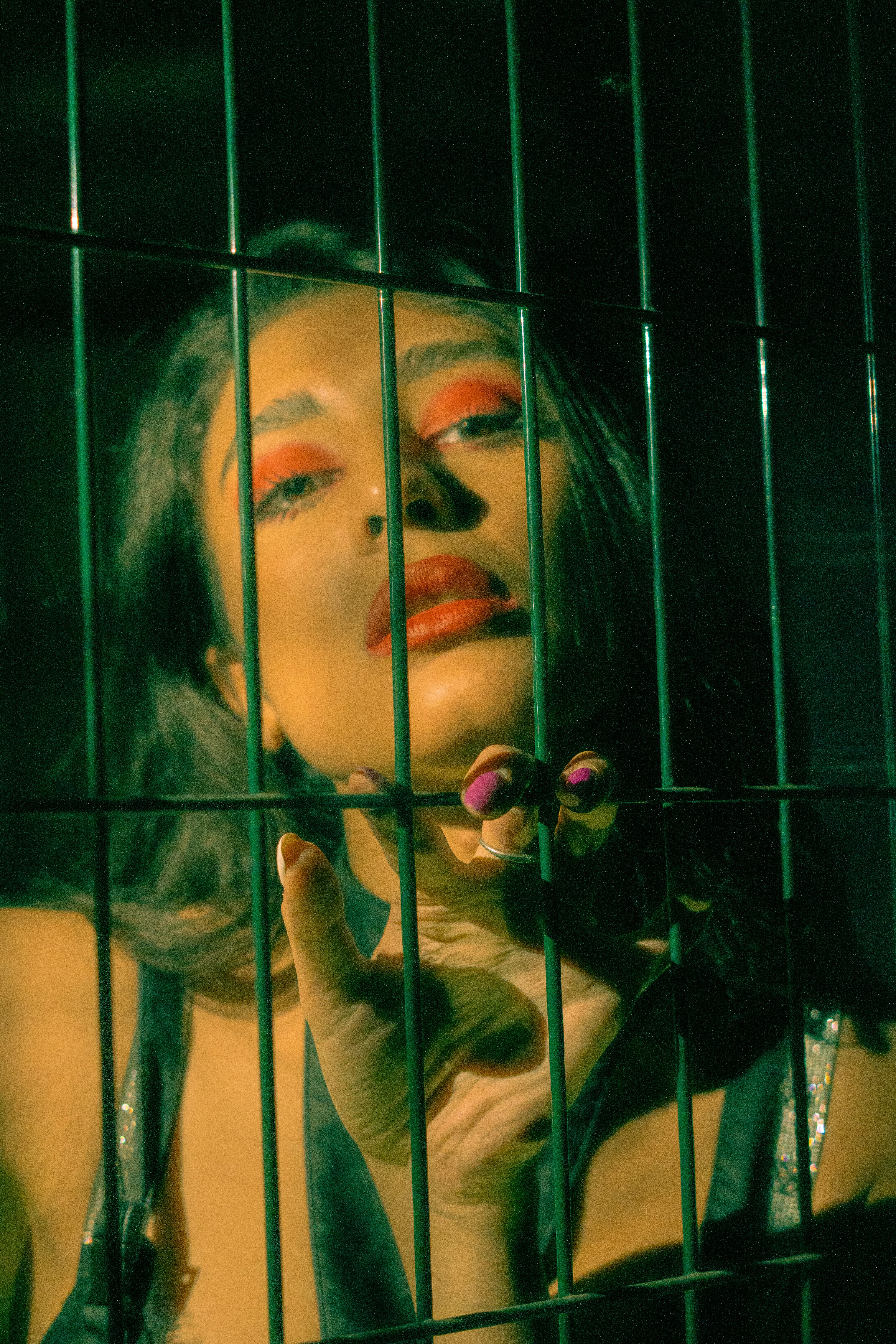 a woman behind a cage holding a flower