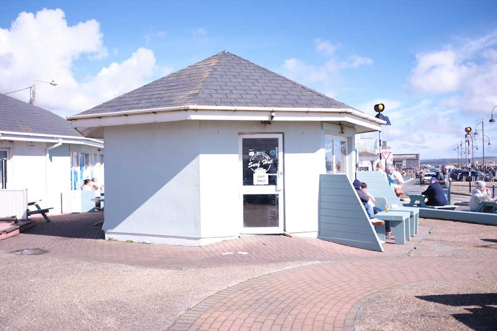 a group of people sitting around a small white building