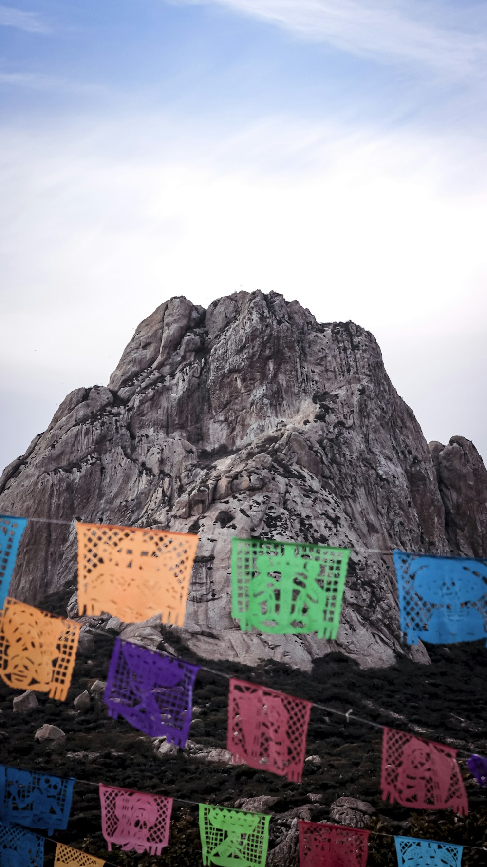 a mountain with a bunch of colorful flags in front of it