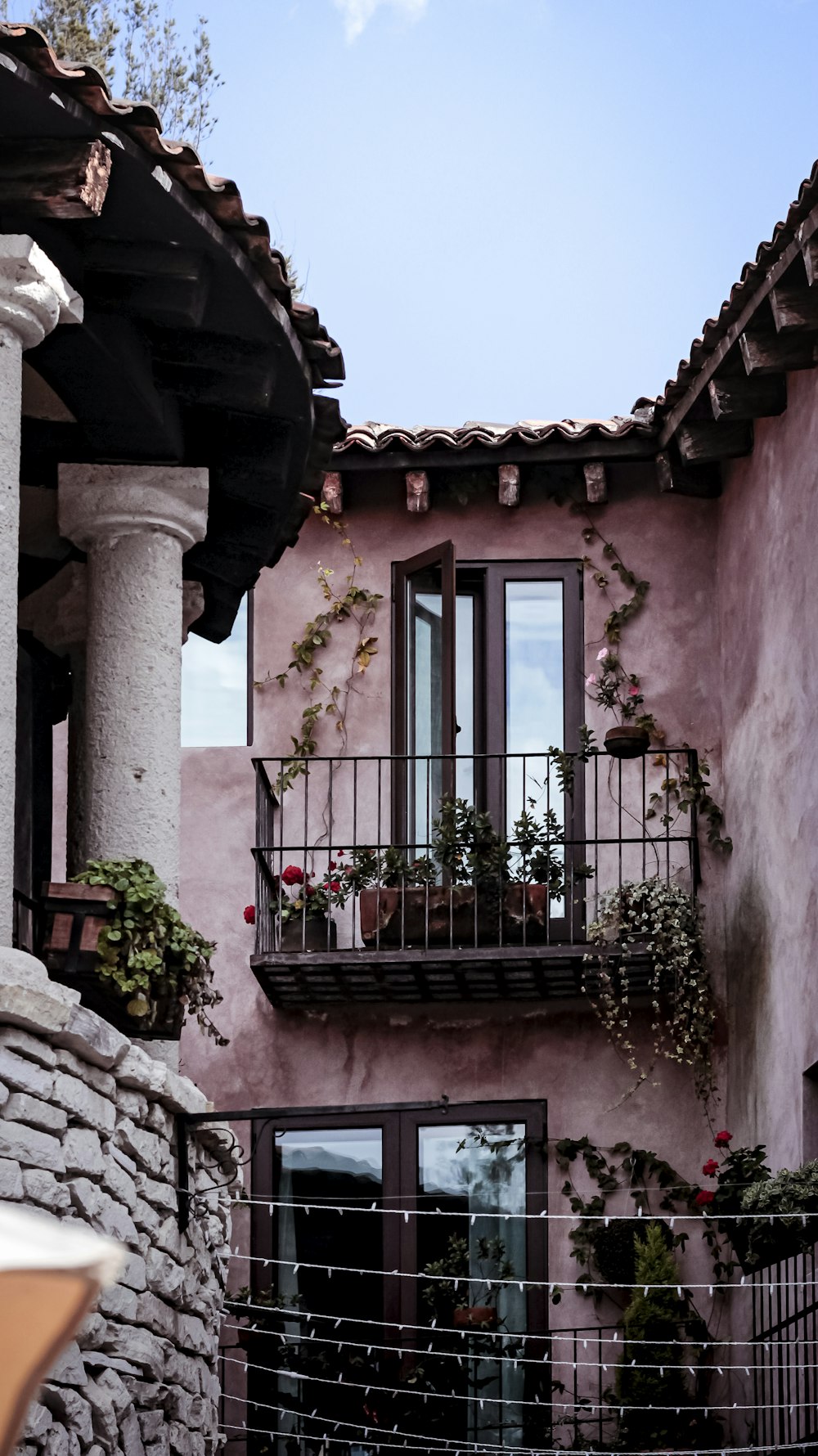 a pink building with a balcony and flowers on the balconies